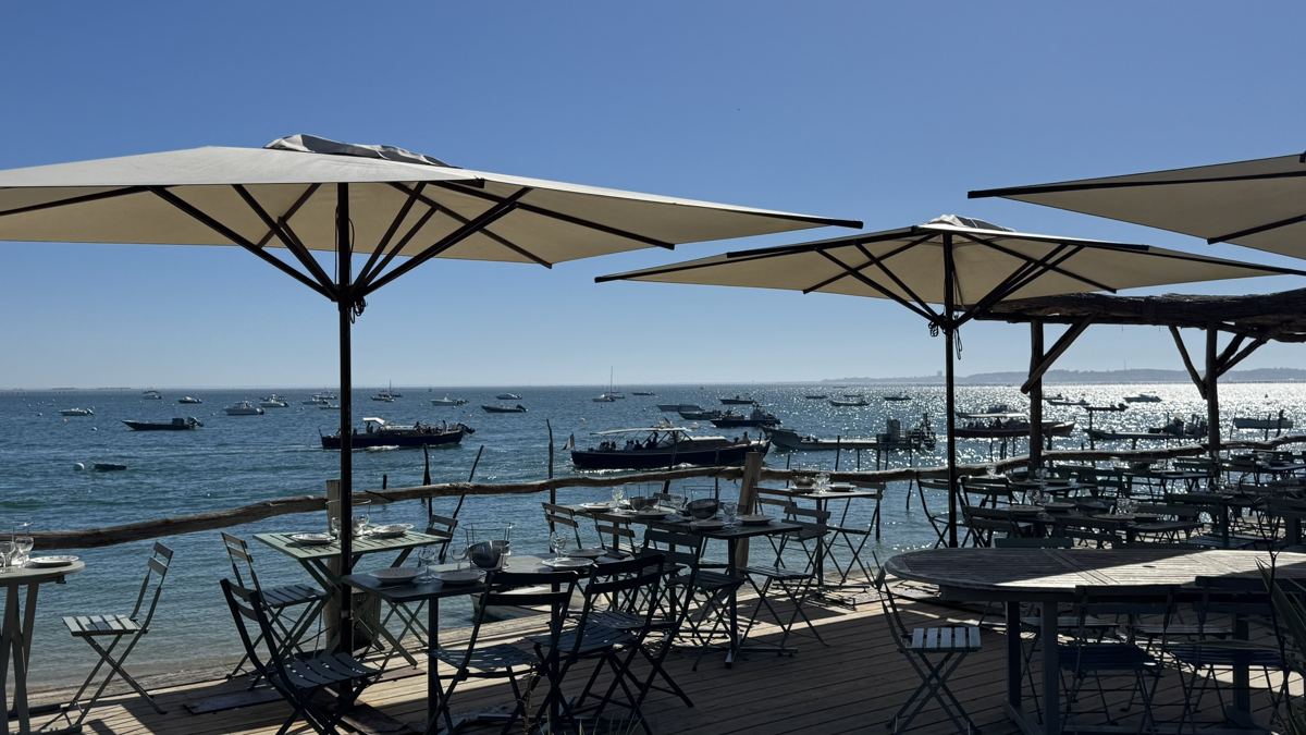 Terrasse sous les parasols face au Bassin, au village de l’Herbe, Cap Ferret