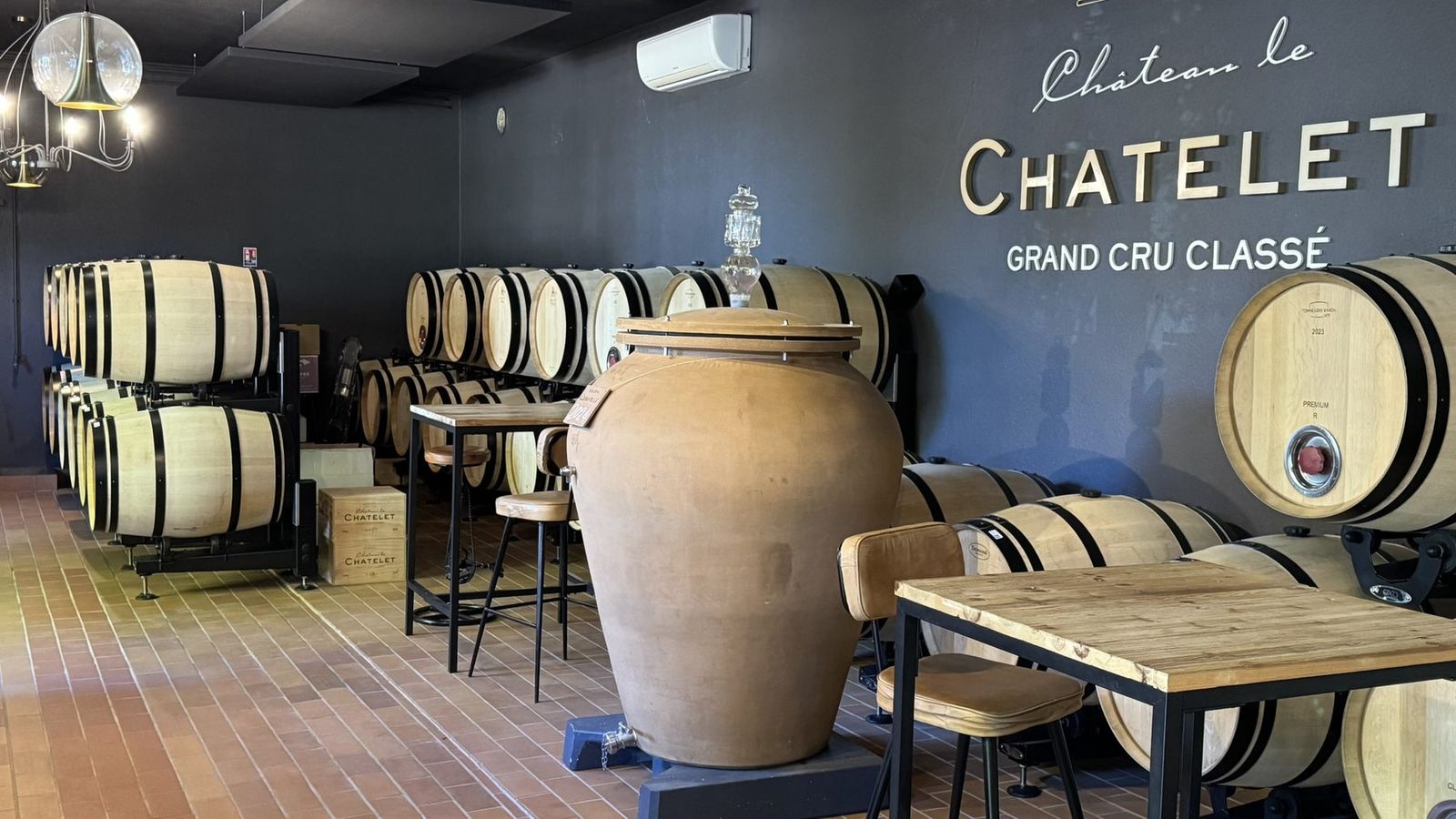 Barriques et jarre en terre cuite dans le chai du château Le Châtelet